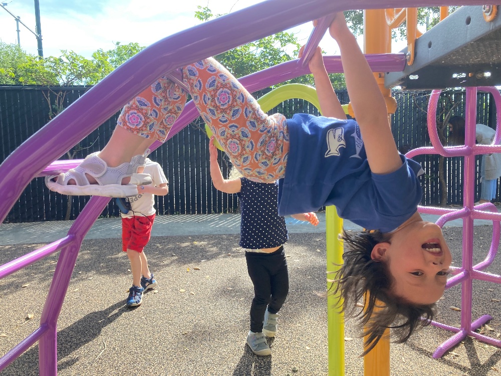 girl playing on climbing frame